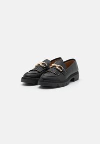 Mustad mustad nahast loaferid tekstureeritud musta tallaga, millel on frantsi detailid ja kuldse tooni ahelatooted.