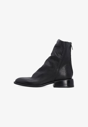 Schwarze Leder-Ankle Boots mit einer schlaffen Gestaltung, spitz zulaufender Spitze und einem niedrigen, klobigen Absatz. Verfügt über einen Seitenreißverschluss für einfaches An- und Ausziehen.