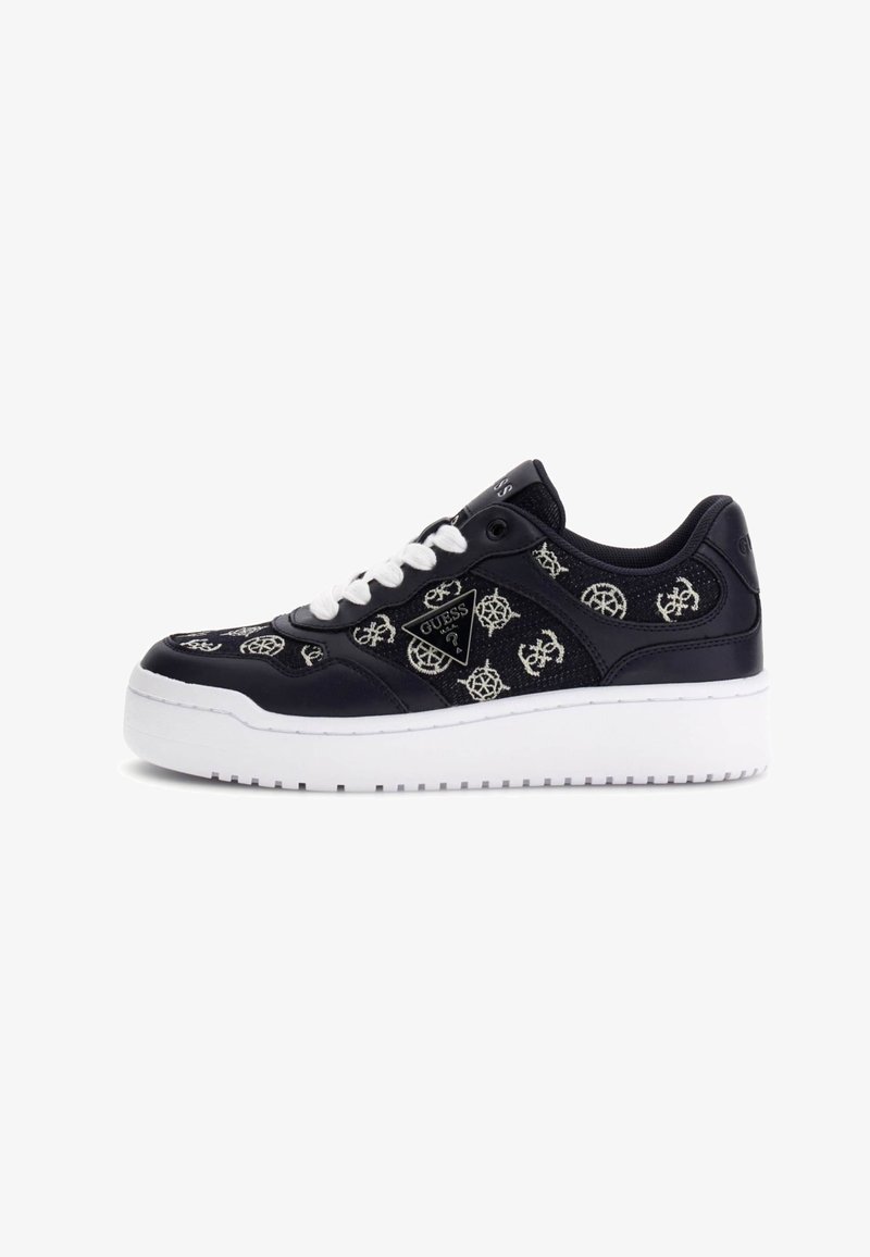Baskets basses noir et blanc avec lacets blancs, dessus en tissu à motifs et semelle blanche épaisse, avec un logo Guess sur le côté.