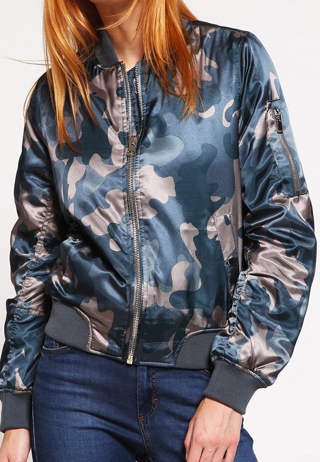 Bomberka w kamuflażu w błyszczącym odcieniu teal i szarości, z zamkiem z przodu, ściągaczami przy mankietach i kieszenią na zamek na lewym rękawie.