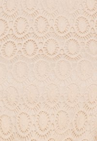 Spitzenstoff in hellem Beige mit einem Muster aus ovalen Motiven und gewellten Kanten, das über eine zarte Textur und aufwendige Details verfügt.