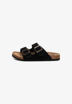 Sandalias de ante negro con dos correas ajustables, acentos de hardware dorado, plantilla de corcho y suela de goma texturizada. Diseño plano, estilo de punta abierta.