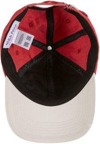 Rdeča in črna tkaninska kapa s kremnim robom. Znotraj ima črno podlogo in kovinski gumb. Oznaka s QR kodo je vidna.