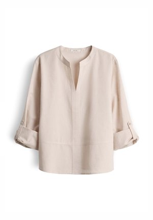 Blouse beige à manches longues avec un col en V fendu, col rond, et poignets retroussés maintenus par des boutons.