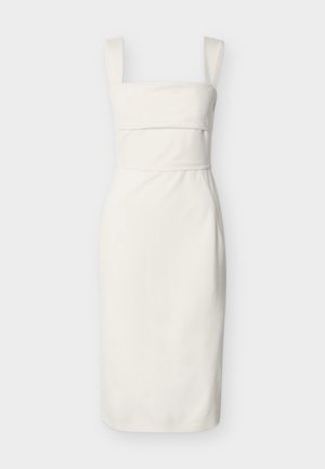 Balta piedurkņu kleita ar platiem siksnām un pieguļošu uzkrūti, ceļgalu garuma ar taisnu svārku vienkāršā fonā.