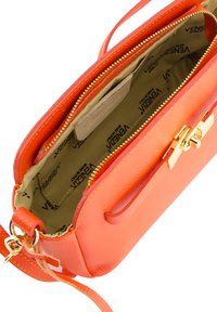Leder-Crossbody-Tasche in leuchtendem Orange mit goldenen Beschlägen. Verfügt über einen Reißverschluss oben, ein geräumiges Innenfutter aus beigem Stoff mit Logo-Muster.