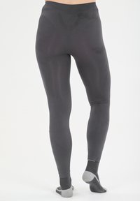 Harmaat legginsit, joissa on sileä pinta, tiukka siluetti ja korkea vyötärö. Ne on yhdistetty harmaisiin nilkkasukkiin, joissa on pieni suunnittelukontrastia.