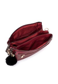Borsa a tracolla in pelle bordeaux con chiusura a zip, due scomparti principali, texture liscia e un pom-pom nero con dettagli in oro.