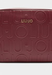Borsa in pelle marrone con design del logo impresso. Dettagli in metallo dorato sul davanti. Texture liscia con forma rettangolare.