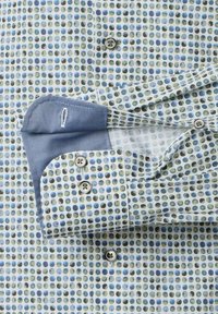 Button-up shirt featuring a light blue base with multicolored polka dots in blue, green, and brown. Cuff displays a solid blue accent.