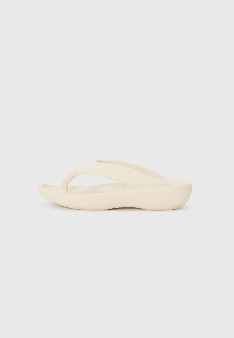 Vaaleanbeige flip-flop minimalistisella designilla. Tässä on thong-tyylinen hihna ja teksturoitu pohja. Valmistettu pehmeästä, joustavasta materiaalista.