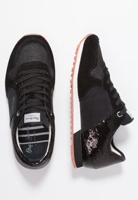 Svarta träningssneakers med ovandel i mocka och mesh, snörning, texturerade detaljer och gummisula med rosa inslag.