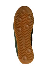 Gummisneaker sål i orange med texturerat vågigt mönster och cirkulära grepp. Sidopaneler i mörkgrön med synliga sömnadsdetaljer.