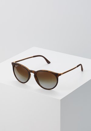 Óculos de sol tartaruga com lentes degradê, armações redondas e hastes finas. Apresenta um logo discreto na arma e um acabamento suave.