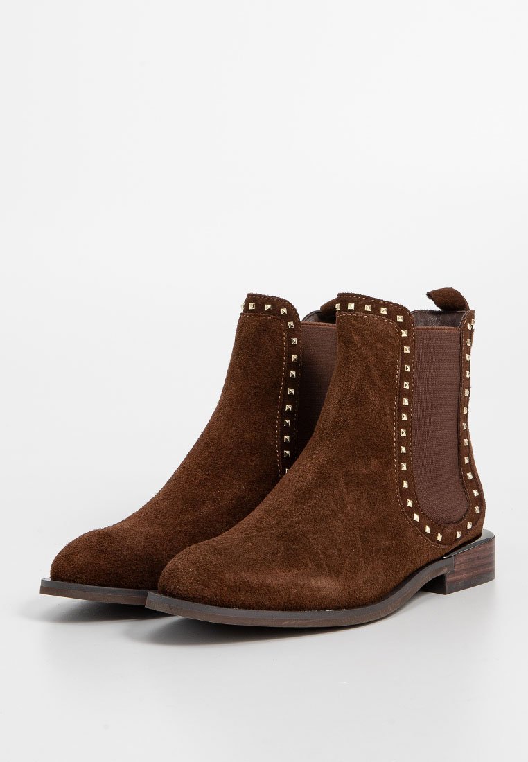 Braune Wildleder-Stiefeletten mit elastischen Seiteneinsätzen, goldenen Nieten-Akzenten, einer runden Zehenpartie und einem niedrigen Holzabsatz.