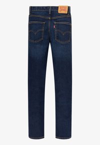 Jeans de denim azul oscuro con corte recto, costuras amarillas en contraste y dos bolsillos traseros con un diseño distintivo. Parche de cuero en la cinturilla.