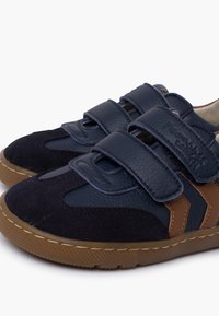 Navy blue shoes with brown accents, made of leather and suede, featuring Velcro straps and a textured rubber sole.