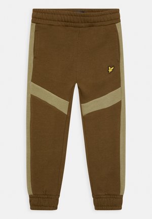 Brune joggingbukser med lysegrønne sidepaneler, elastisk taljebånd og manchetter. Har et lille gult logo på højre lår.