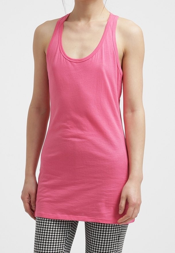 Różowy bezrękawnik z okrągłym dekoltem, wykonany z gładkiego materiału, w połączeniu z legginsami w czarno-białą kratę typu houndstooth.
