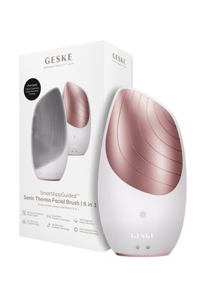Hvid og rosaguld 6-i-1 sonisk termisk ansigtsbørste med tekstureret renseflade, vist med dens æske med produktfunktioner og branding.