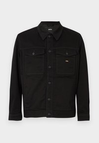 Čierna rifľová bunda s klasickým dizajnom, s zapínaním na gombíky vpredu, dvoma náprsníkmi a jemným zlatým detailom loga.