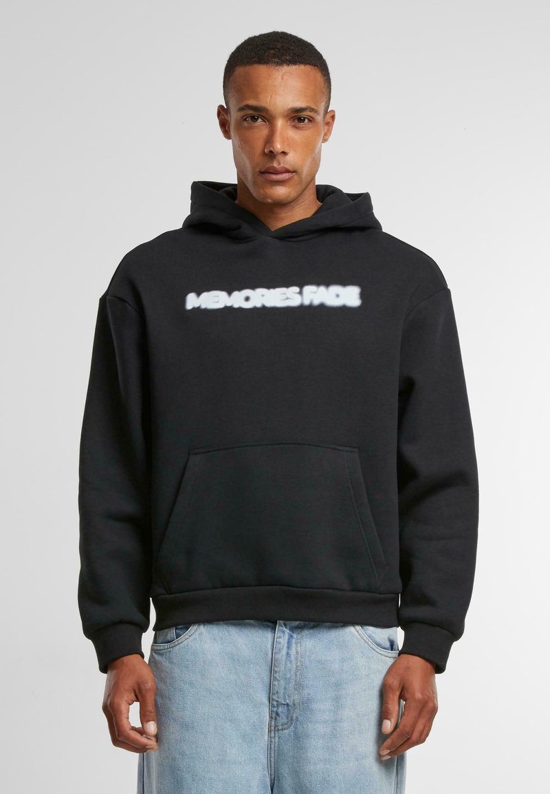 Zwarte hoodie met een voorzak en witte tekst "MEMORIES FADE" over de borst. Gemaakt van zachte stof, met een capuchon met trekkoord.