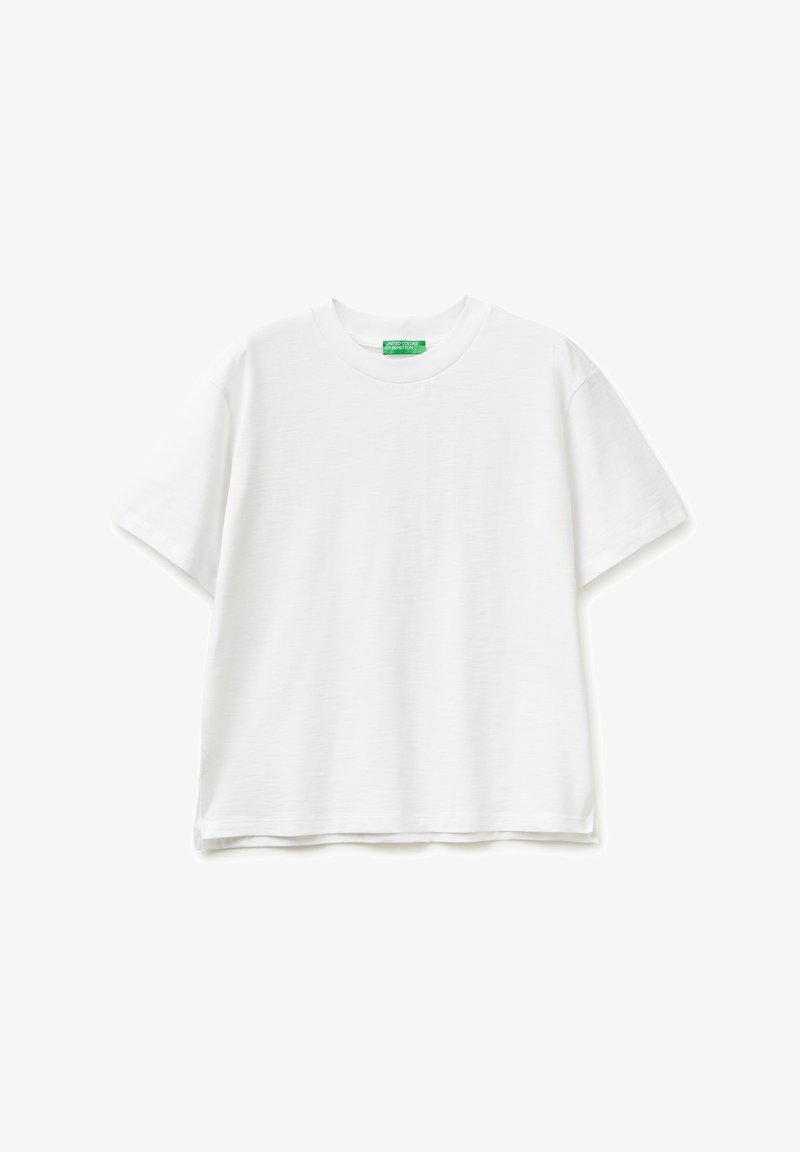 Camiseta blanca lisa de manga corta y cuello redondo, extendida y colocada plana, con una etiqueta verde en el cuello que muestra el nombre de la marca.