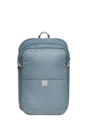 Lichtblauwe rechthoekige rugzak met een voorvak met ritssluiting, een bovenhandvat, zijcompressieriemen en een klein label op het voorpaneel.