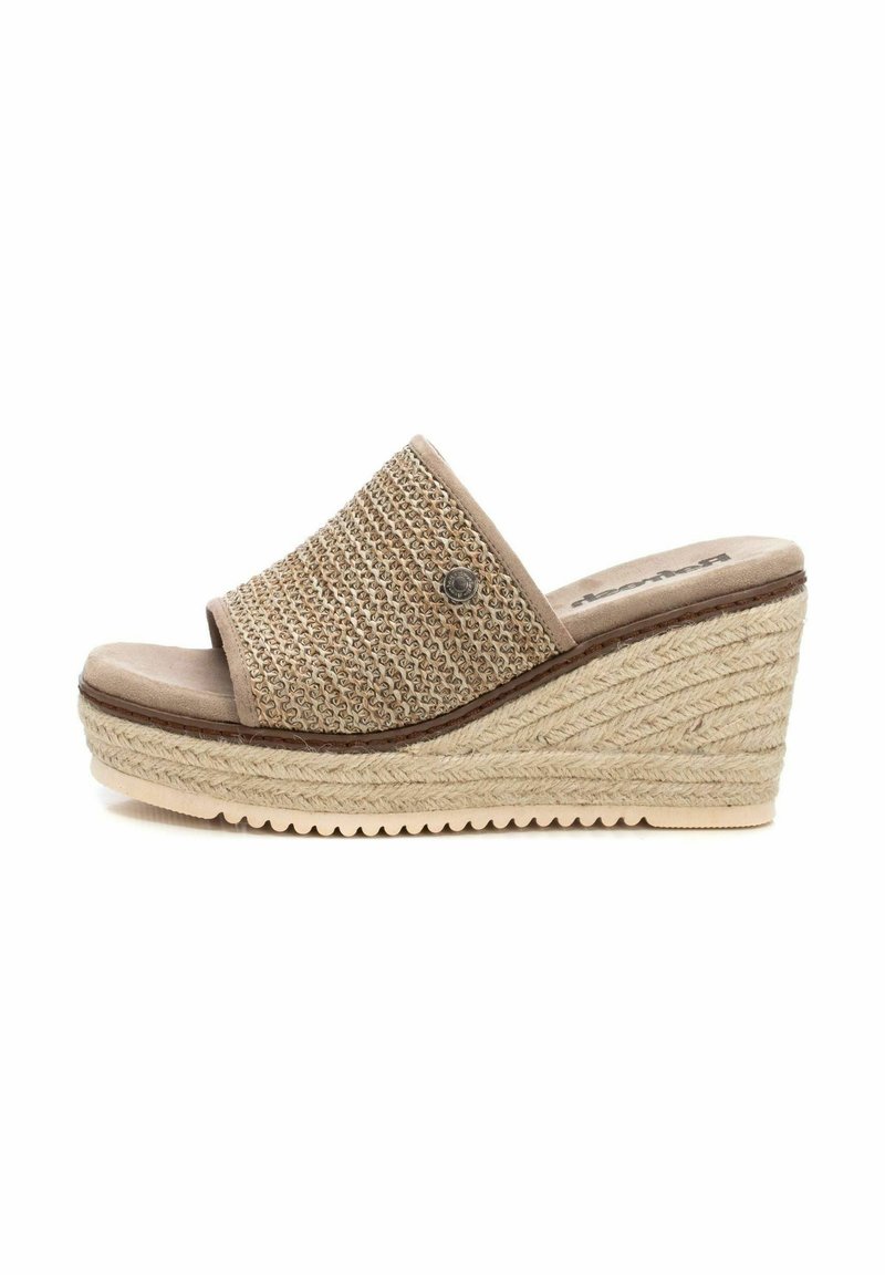 Sandalia de cuña con parte superior de tela beis trenzada, puntera abierta y suela texturizada estilo espadrille. Presenta un acento decorativo metálico.