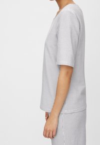 Haut à manches courtes rayé blanc et marine, doté d'un col rond et d'une coupe décontractée, confectionné en tissu de coton lisse.