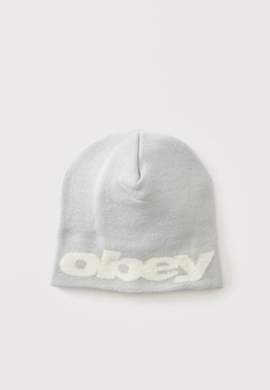 Светлосива плетена шапка тип бини с бял текст с малки букви "obey", плетена близо до долния край, положена върху бял фон.