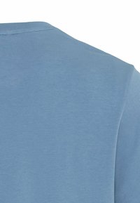 Hellblaues T-Shirt mit rundem Halsausschnitt und kurzen Ärmeln, hergestellt aus einem weichen, glatten Stoff mit einer leicht strukturierten Oberfläche.