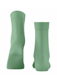 Une paire de chaussettes de cheville vert clair, montrées de face et de dos, avec des poignets côtelés sur un fond blanc.