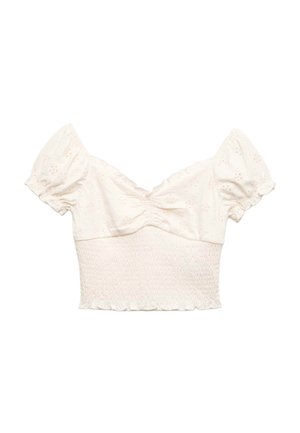 Blusa corta color blanco roto con mangas cortas abullonadas, pecho fruncido, ojales florales bordados y cintura fruncida con bajo con volantes.