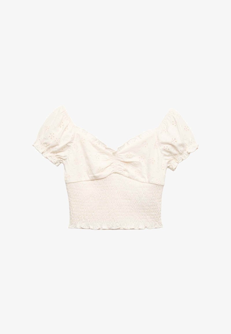 Blusa corta color blanco roto con mangas cortas abullonadas, pecho fruncido, ojales florales bordados y cintura fruncida con bajo con volantes.