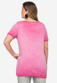 Lyhythihainen, vaaleanpunainen ombre-paita pehmeällä pinnalla, jossa on pyöreä pääntie ja käännetyt hihansuut. Takakuvassa näkyy rento istuvuus.