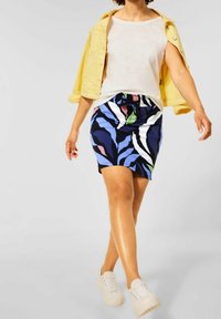 Flerfärgad kjol med blå, vit, grön, rosa och svart abstrakta mönster; tillverkad av lätt tyg med resår i midjan.