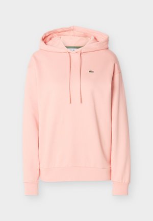 Sweat à capuche rose clair avec cordons et petit logo crocodile vert sur le côté gauche de la poitrine, manches longues et poignets côtelés.