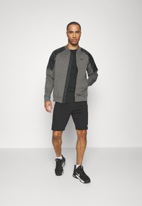 Nike Performance THERMA NOVELTY BOMBER - Chaqueta de entrenamiento - charcoal heather black/black