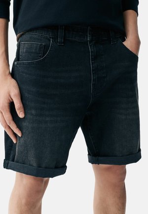 Jeans šortsi u tamnoplavoj boji, ravnog kroja, s ovratnikom na rubovima, dizajnom s pet džepova i blagim izbljeđenjem na tkanini.
