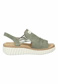 Sandale en suede vert avec un bout fermé, des brides entrecroisées et une semelle blanche à nervures. Présente une semelle en fibre naturelle et de petits emblèmes.