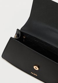 Portafoglio in pelle nera con finitura testurizzata, chiusura in metallo dorato, tasca interna con zip e marchio protetto. Vista aperta che mostra i compartimenti.