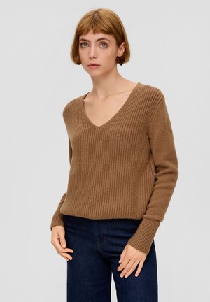 Bruine gebreide trui met een V-hals, ribbeltextuur en lange mouwen, gecombineerd met donkerblauwe jeans. Eenvoudig, casual ontwerp.