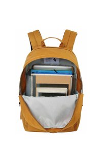Sac à dos jaune moutarde ouvert montrant un ordinateur portable, un carnet à spirale, des dossiers et des livres bien rangés à l'intérieur.