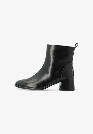 Bottine en cuir noir avec talon bloc et languette à l’arrière, vue de profil sur fond blanc.