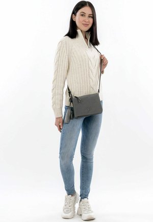 Gray crossbody bag with a textured finish, adjustable strap, and decorative tassel accent. Features minimalistic design and a small logo.