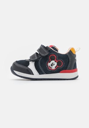 Baskets bleues à fermeture velcro avec un accent blanc et rouge, une semelle en caoutchouc noire, et une applique Mickey Mouse rouge et noire sur le côté.