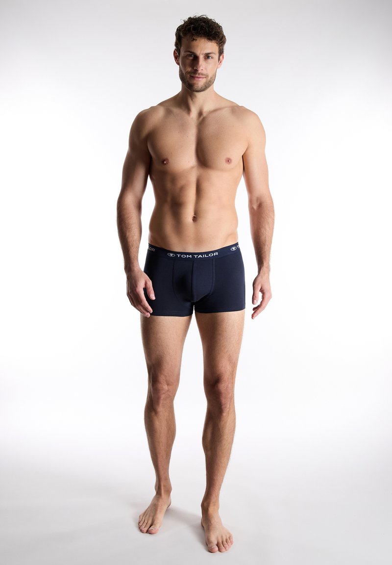Navy blue men's boxer shorts with a soft, elastic waistband featuring the "TOM TAILOR" logo. Smooth fabric and mid-thigh length design.