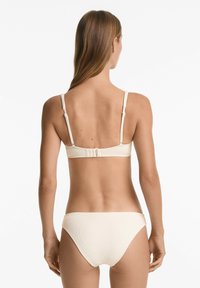 Crème kleurig bikini set met een textuur ribbel ontwerp, verstelbare bandjes en een haaksluiting aan de achterkant. Eenvoudige en functionele stijl.