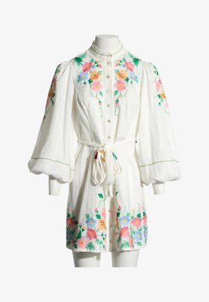 Vestido blanco de manga larga con bordado floral colorido, cierre de botones en la parte delantera, mangas abullonadas y cinturón de cuerda anudado en la cintura.
